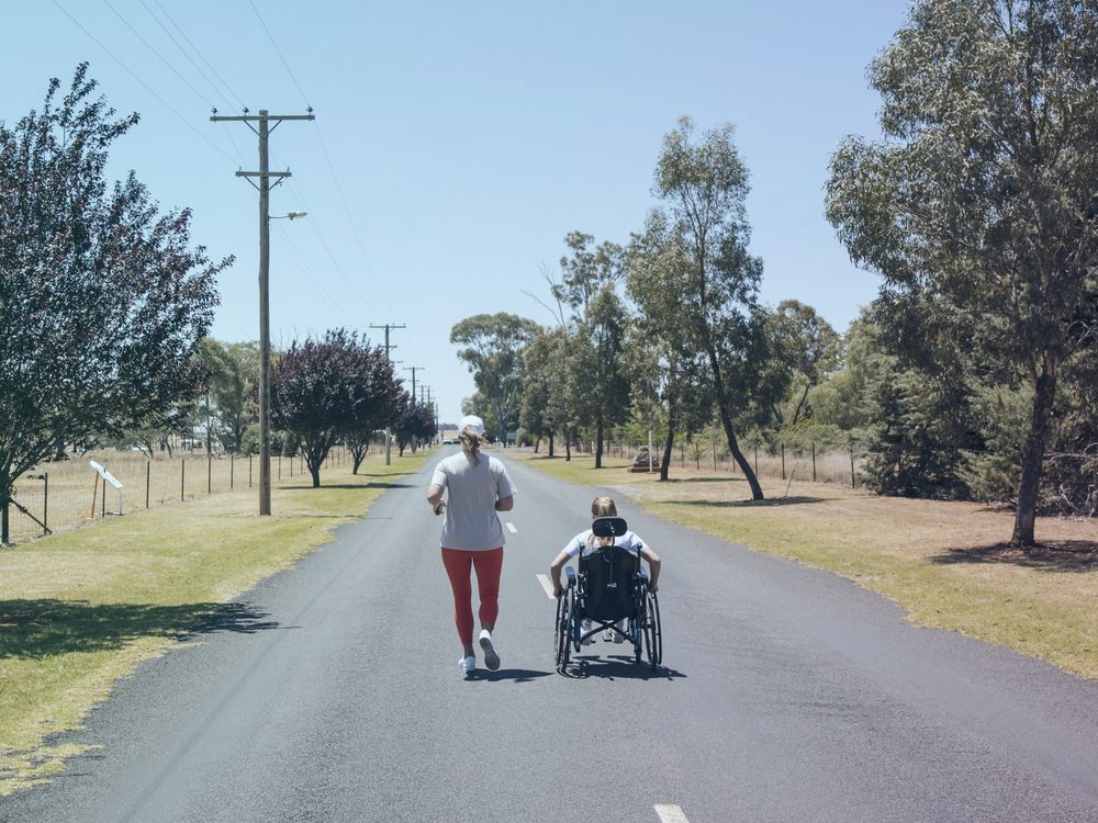 Wheelchair user and runner on a country road