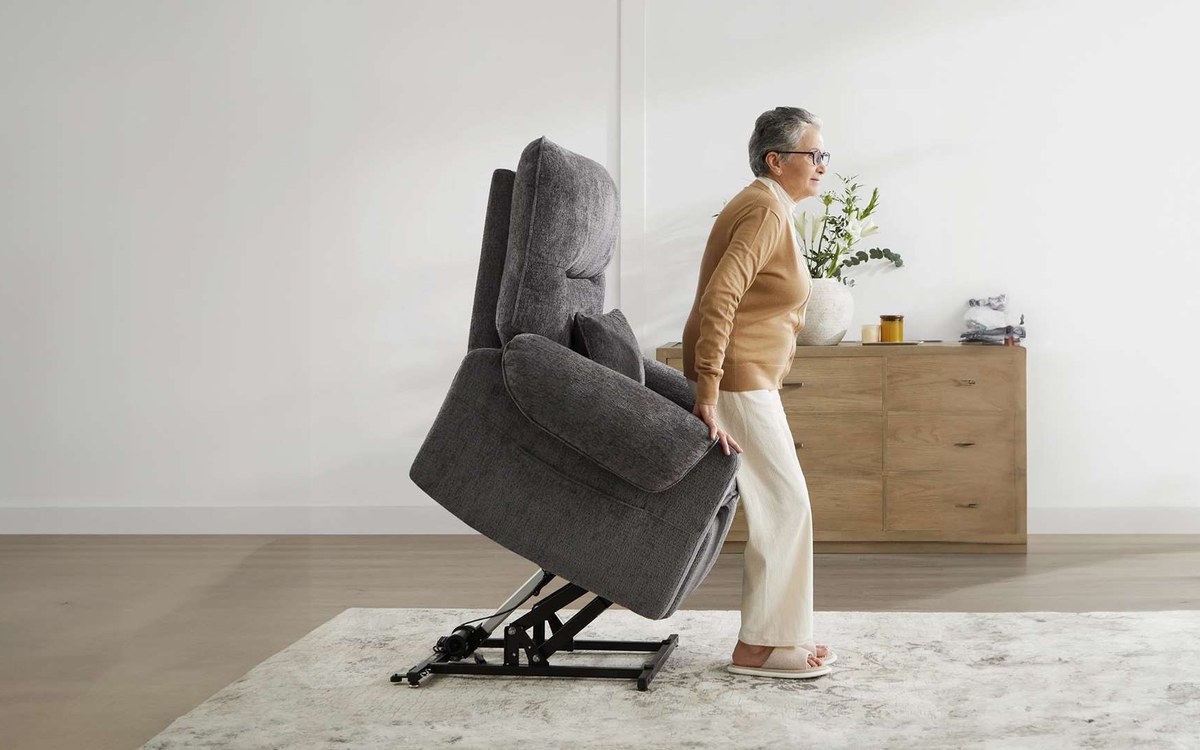Woman standing up with help from a lift chair at home