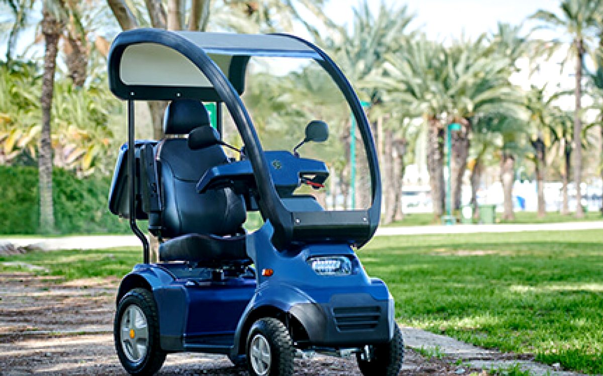 Mobility scooter with canopy parked on a park path