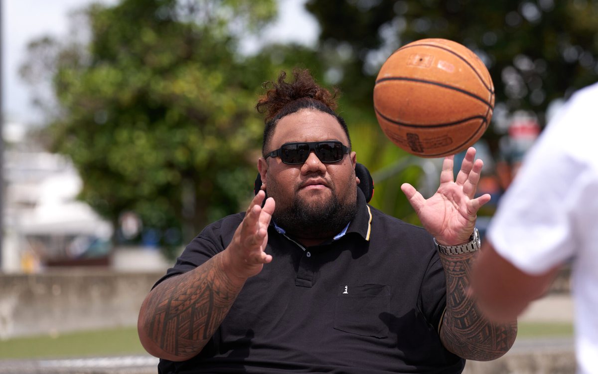 Man catching a basketball while seated in his wheelchair with supportive seating